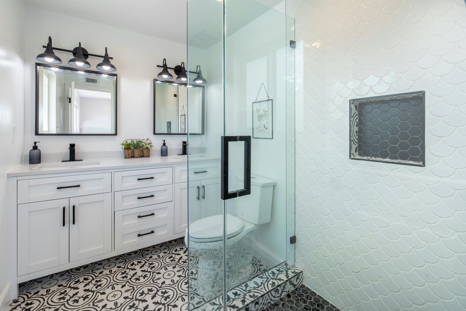 Modern bathroom with glass shower enclosure, white vanity, and patterned floor.