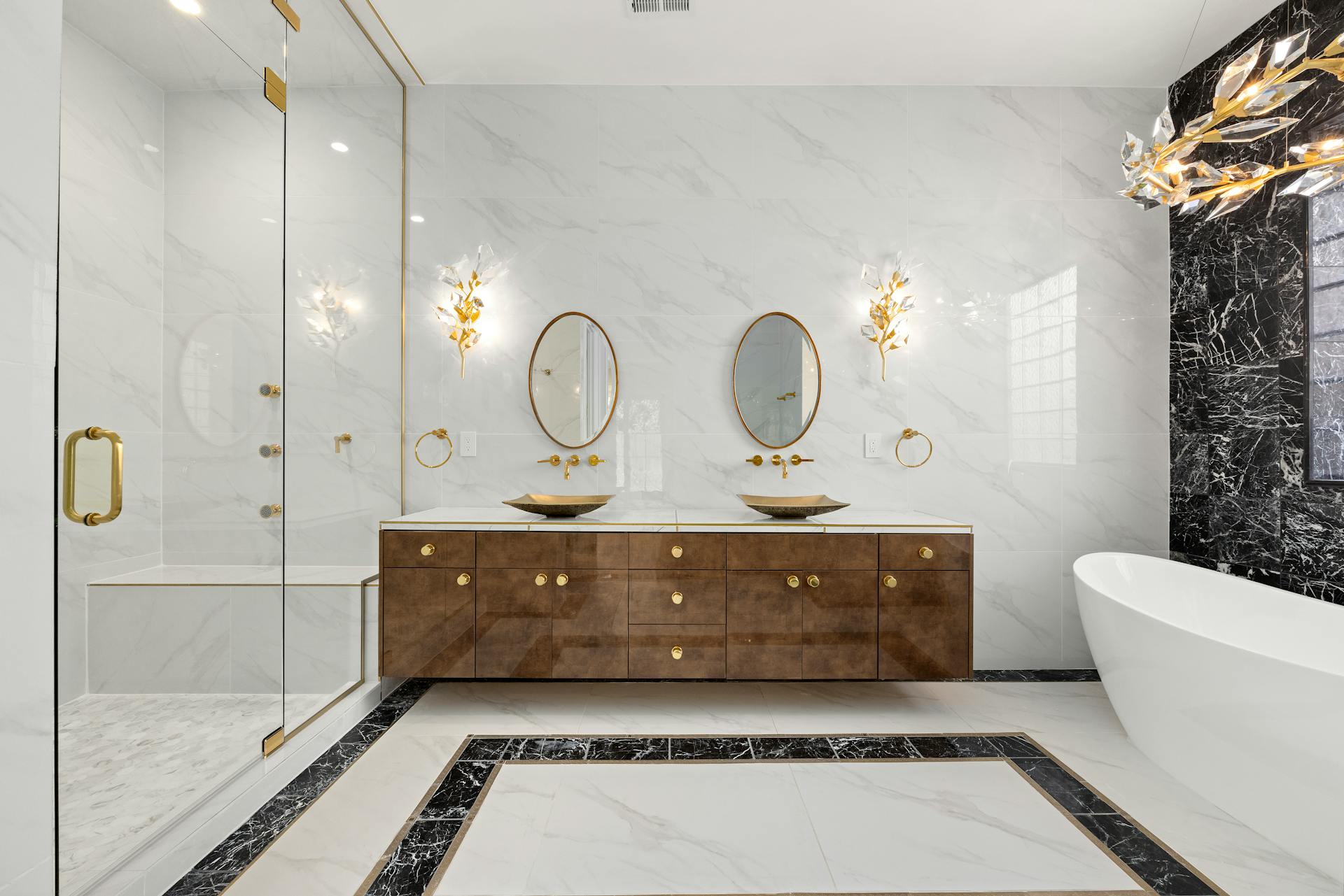 Luxurious bathroom with wooden vanity, marble walls, and a freestanding bathtub.