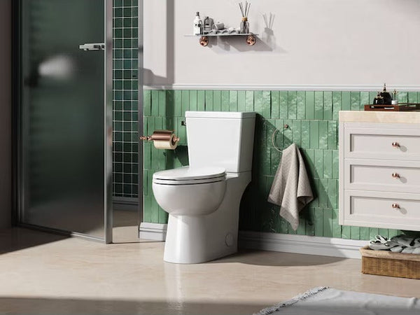 Bathroom with a toilet, green tiled wall, and white vanity.