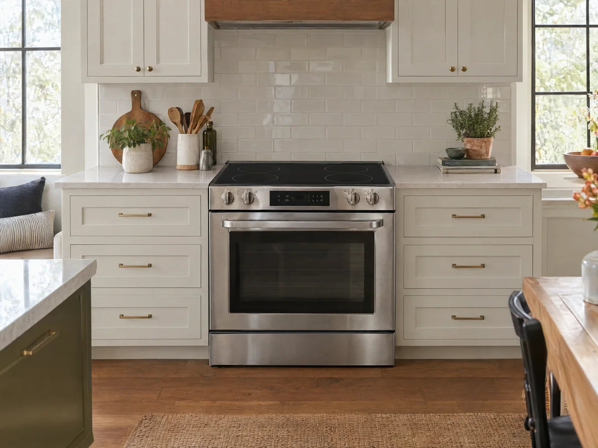 Modern freestanding stainless electric range with smooth black glass-ceramic cooktop and an oven below, exactly four subtle heating-zone circles, stylish light kitchen.