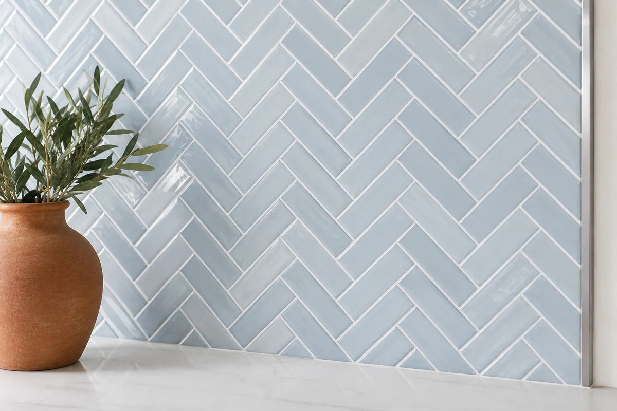 Blue herringbone backsplash finished with a slim metal edge