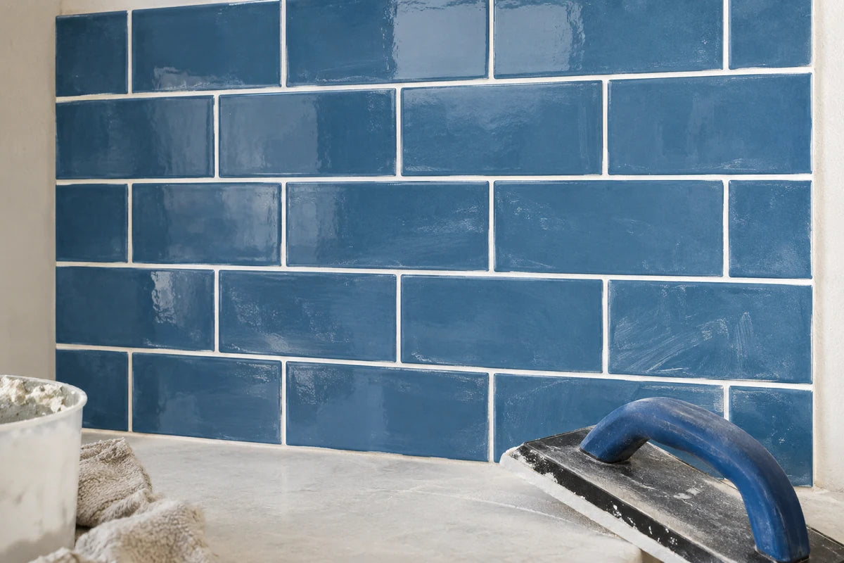 Freshly grouted blue tile beside a grout float