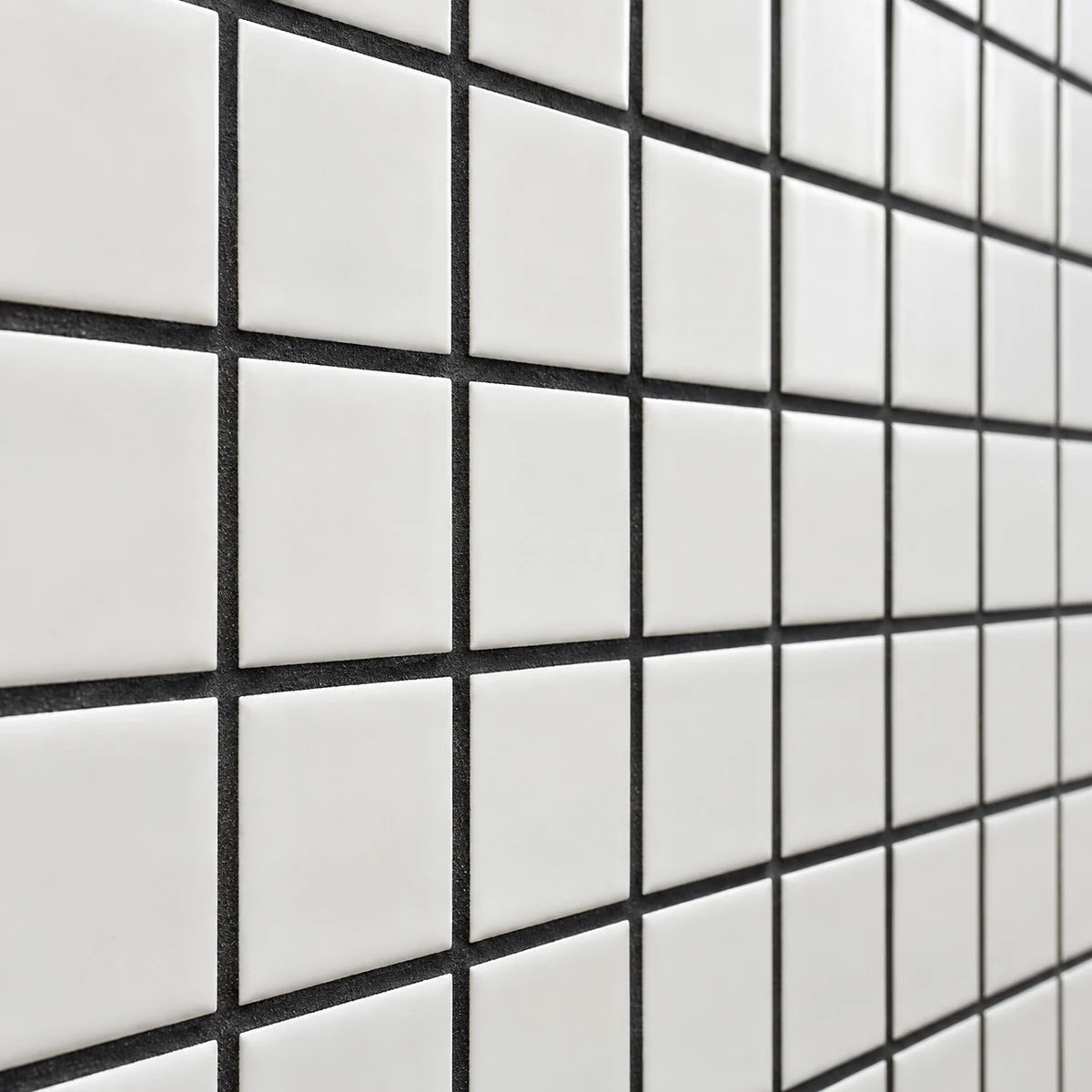 Black grout forming a crisp grid between white square porcelain tiles