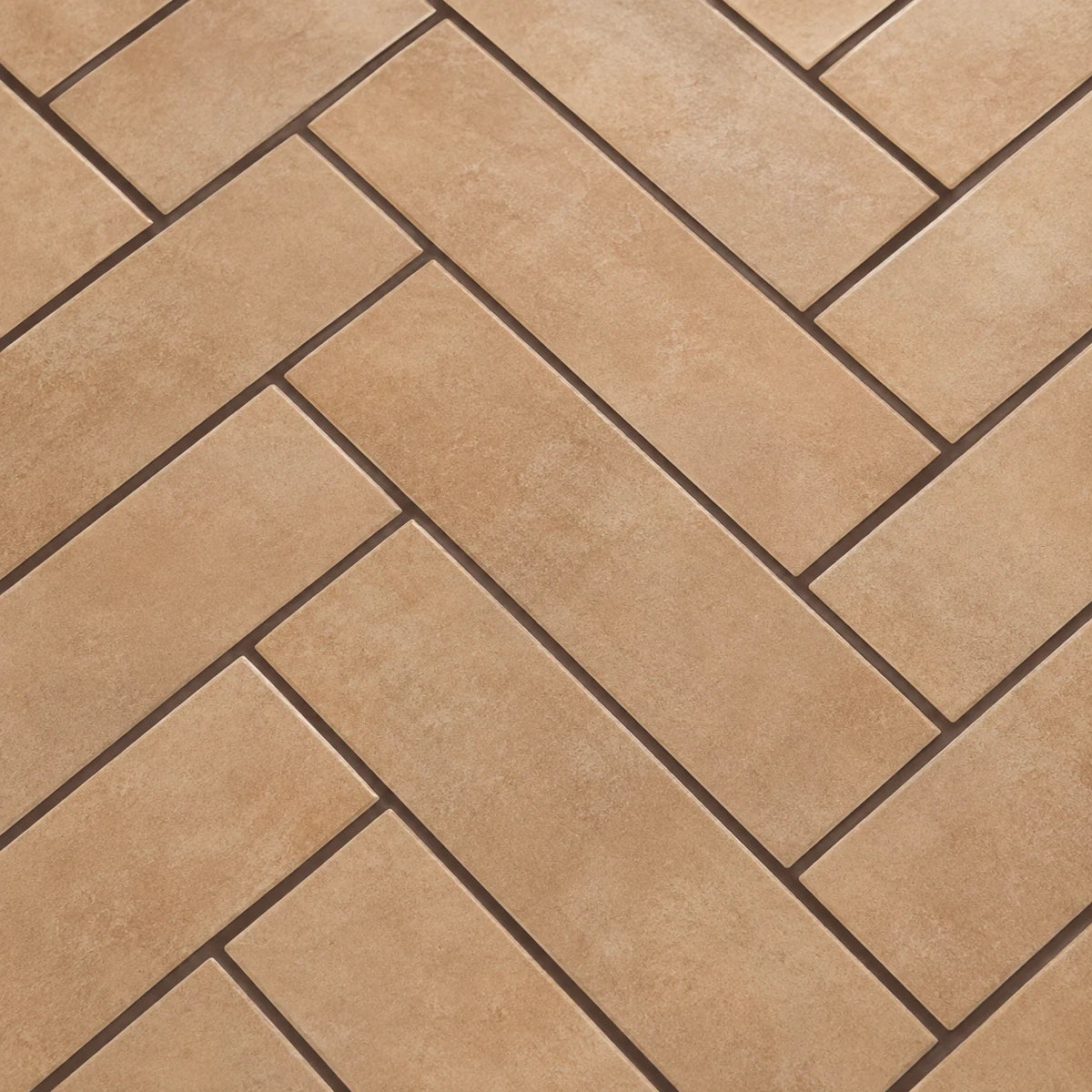 Chocolate-brown grout defining caramel herringbone ceramic tiles