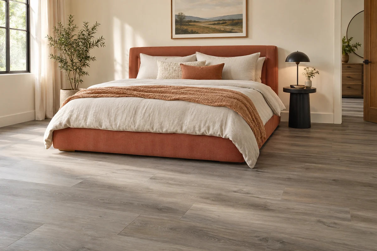 Graywashed vinyl flooring in a bedroom with a terracotta upholstered bed.