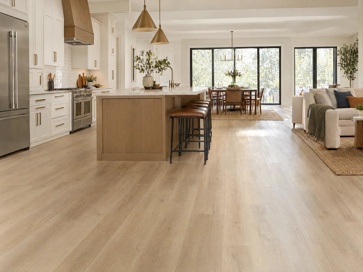 Extra-wide blonde oak-look luxury vinyl plank floor stretching through an open-plan kitchen, long plank lengths and subtle embossed wood texture, daytime.