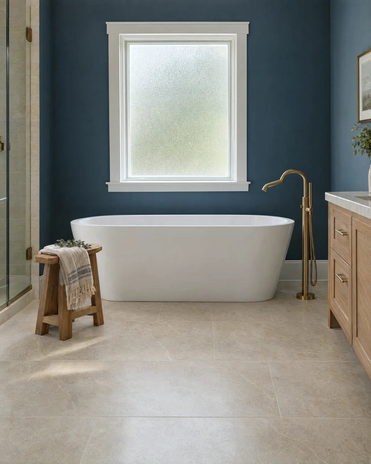 White soaking tub beside a blue bathroom accent wall