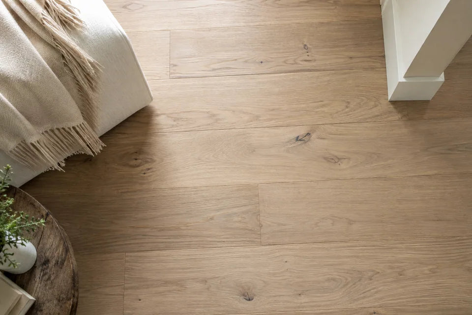 Pale natural oak planks seen overhead beside a cream fabric sample